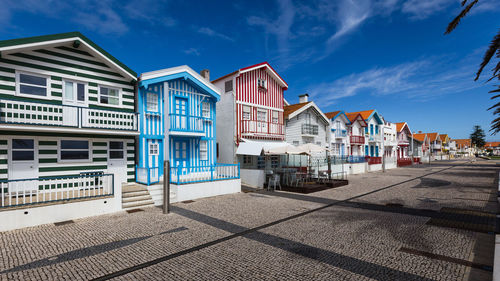 Houses by street against sky in city