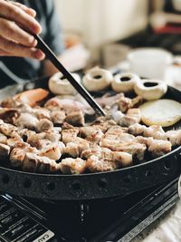 Cropped hand preparing food on stove