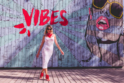 Portrait of woman against graffiti on wall