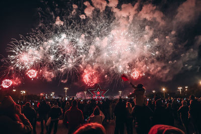 People watching firework display at night