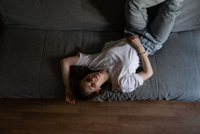 Rear view of woman lying on sofa