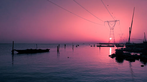 Silhouette sailboat on sea against sky at sunset