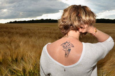 Rear view of woman on field against sky