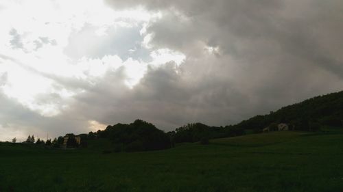 Scenic view of grassy field against cloudy sky