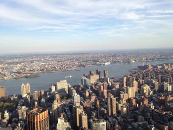 High angle view of city buildings against cloudy sky