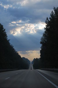 Road amidst trees against sky