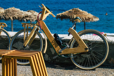 Old bicycle on beach against blue sea