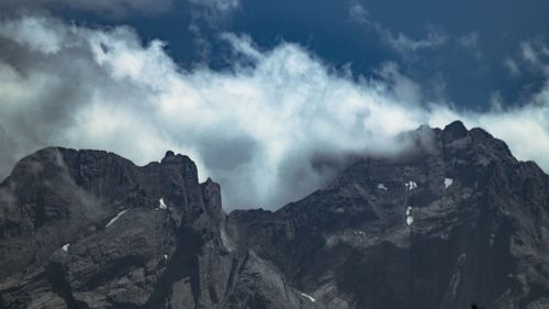 Low angle view of rocky mountains against sky