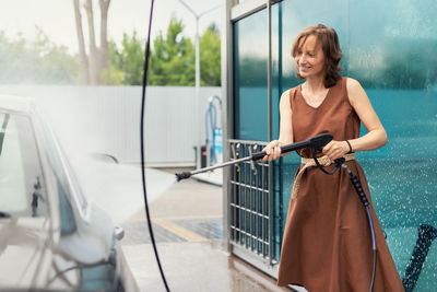 Full length of woman standing in car