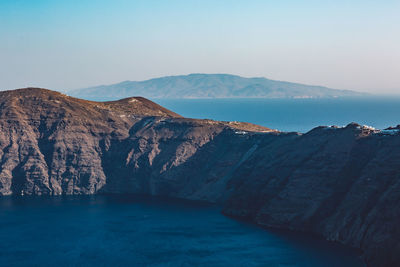 Scenic view of sea and mountains against clear sky