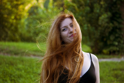 Portrait of young woman against tree