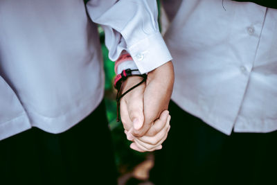 Midsection of couple holding hands