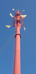 Low angle view of windmill against clear blue sky