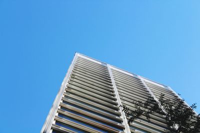 Low angle view of modern building against clear blue sky