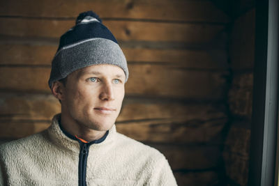 Close-up of thoughtful mid adult man in log cabin