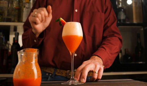 Midsection of man drinking beer in glass