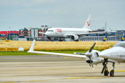 Airplane on airport runway against sky