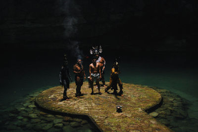 People standing on rock at night