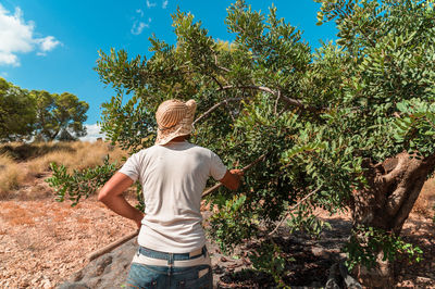 Rear view of woman standing by plants