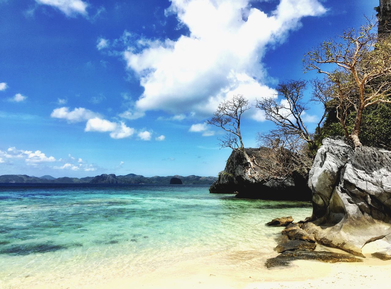 water, sky, sea, tranquility, tranquil scene, beach, scenics, beauty in nature, blue, nature, tree, shore, cloud, cloud - sky, sand, horizon over water, idyllic, day, coastline, rock - object