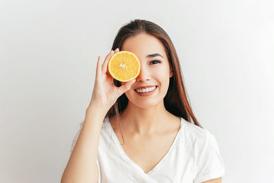 Portrait of a smiling young woman against white background