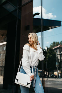 Woman standing on mobile phone in city