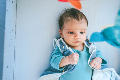 High angle view of baby lying on crib