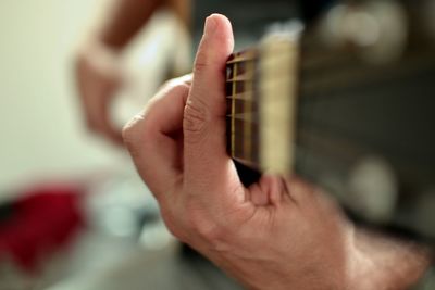 Close-up of man playing guitar