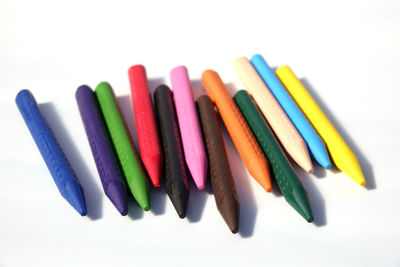 Close-up of colored pencils over white background