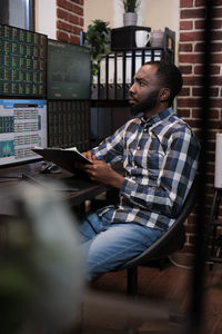 Young male trader working in office