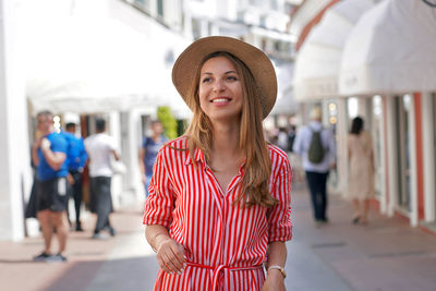 Young fashion beauty woman strolling in capri fashion street look to the side on capri island, italy