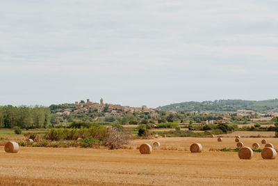 Hay bales on field against sky