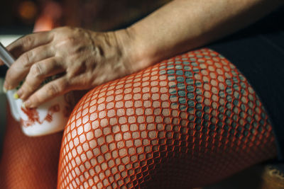 Midsection of woman red stockings holding mug