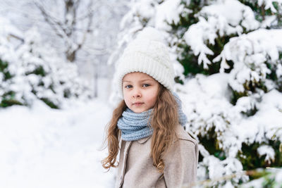 Portrait of girl on snow covered land during winter