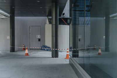 Traffic cones with tape and column by closed door in room