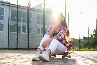 Full length of woman sitting outdoors