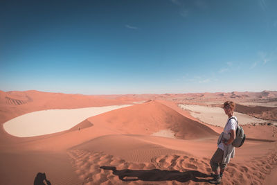 Portrait of female tourist standing at namib desert in naukluft national park during sunny day