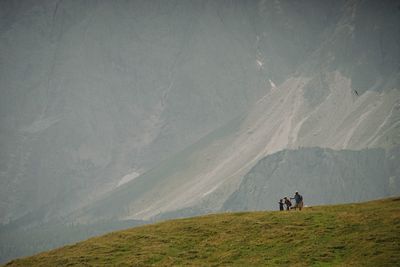 People on mountain against clear sky