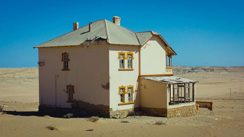 Altes zweistöckiges haus verlassen steht in der wüste.