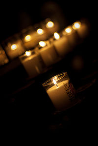 Close-up of illuminated candles in darkroom