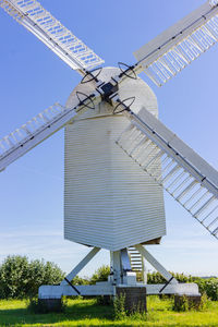 Traditional windmill on field against sky