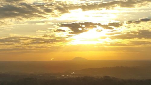 Scenic view of silhouette mountains against orange sky