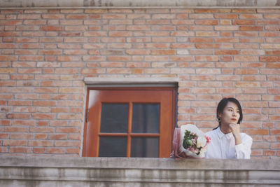 Portrait of woman against wall