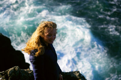 Woman standing on rock against sea