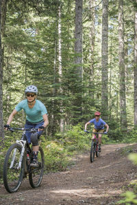 Two female bikers enjoy a trail in sandy, or near mt. hood.