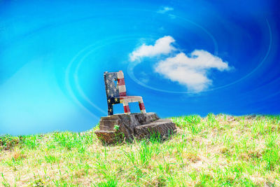 Windmill on field against blue sky