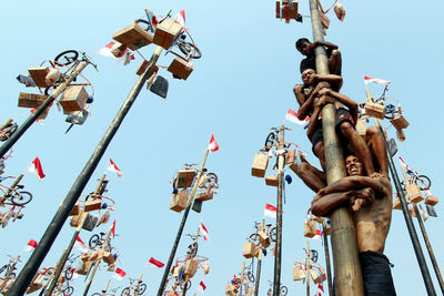 Low angle view of padlocks on metal pole against sky