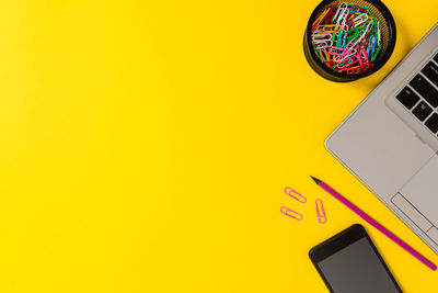 Close-up of smart phone on yellow table