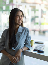 Smiling businesswoman looking away at office