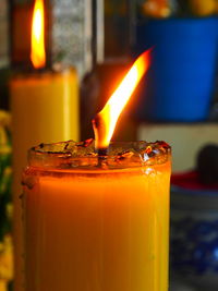 Close-up of lit candle on table against illuminated building